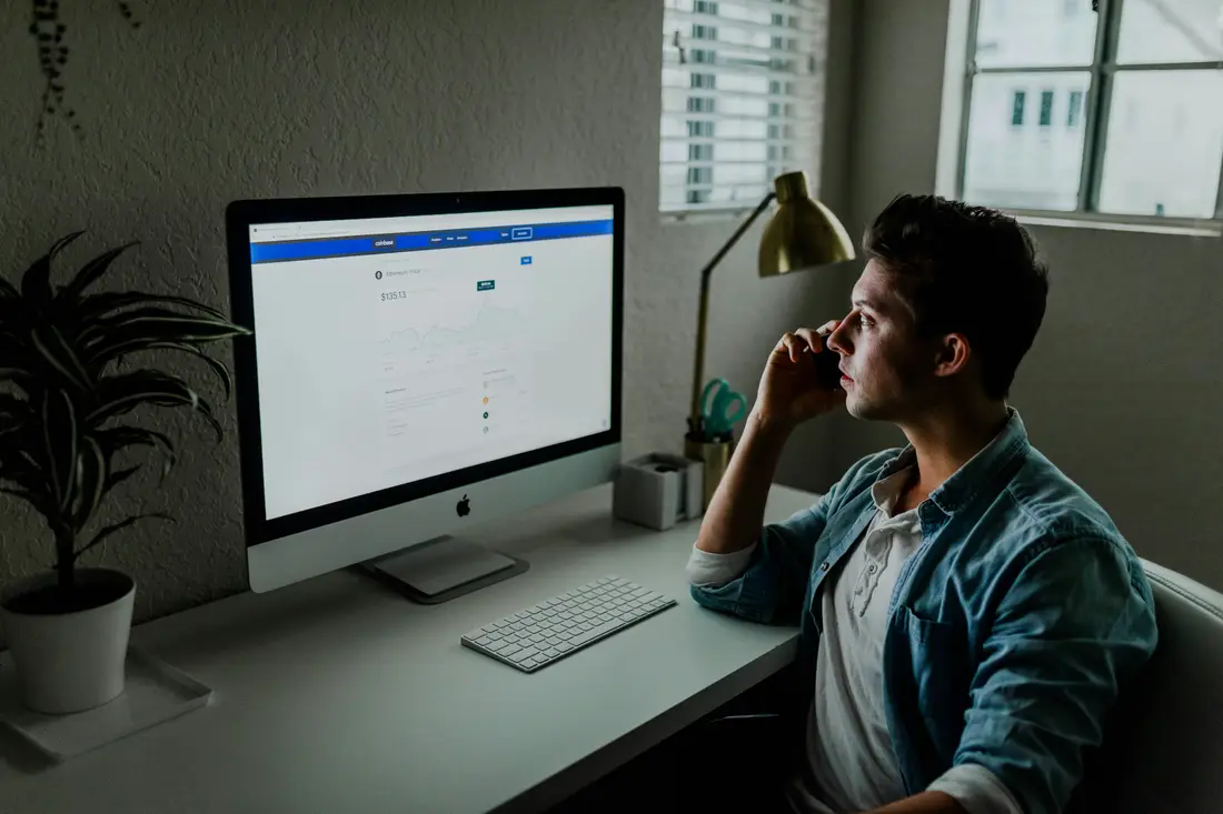 A professional working at a desktop computer while on a call
